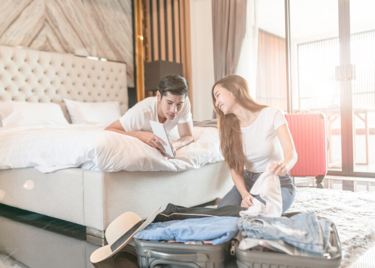 Smiling young couple in hotel bedroom